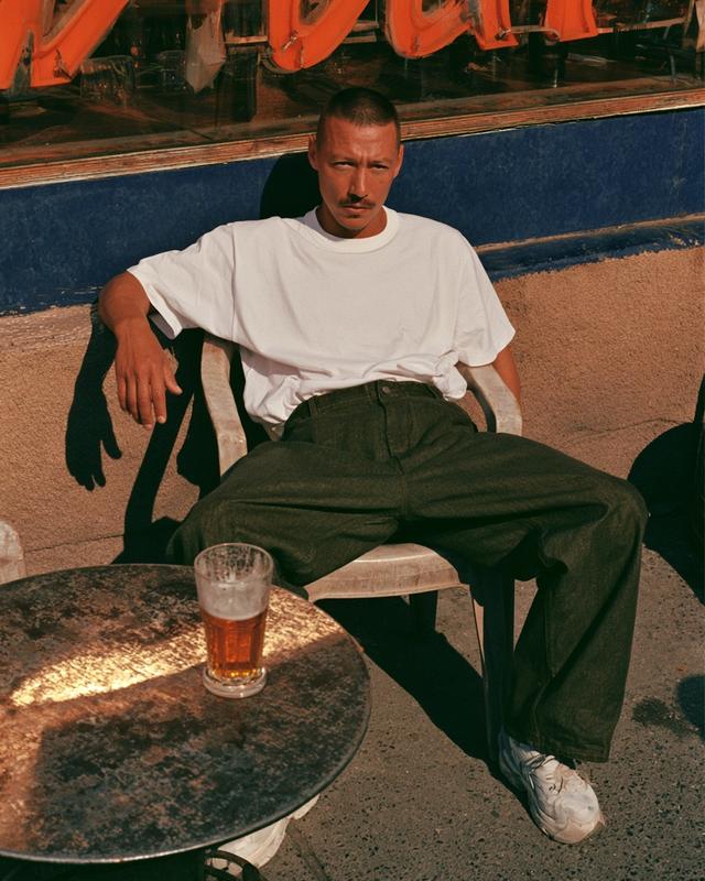 A guy in a white tee sitting backwards on...