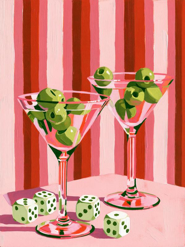 two martini glasses each holding multiple green olives in...