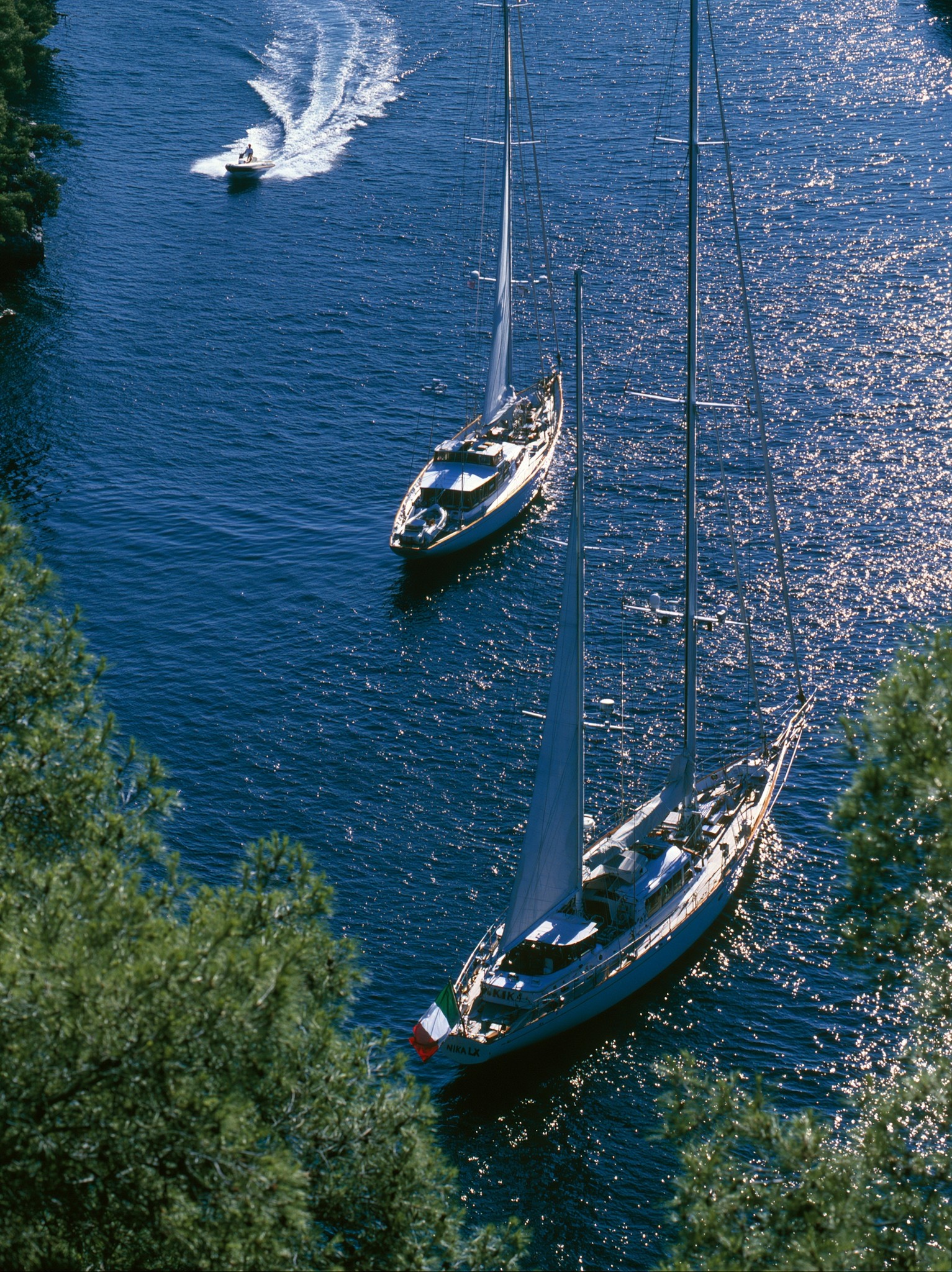 an aerial full shot captures two classic sailing yachts...