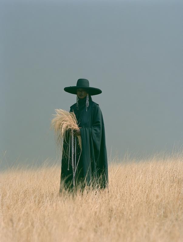 a person in dark attire featuring a prominent wide...